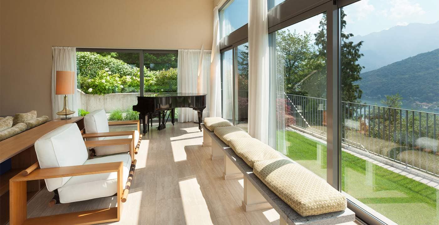 couch and bench in room with large window overlooking balcony